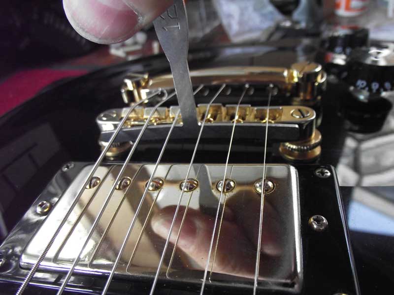 Epiphone bridge saddles reduced, smoothed and slotted to radius