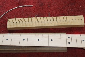 The fret wire is cut to length and kept in order of size in a wooden block