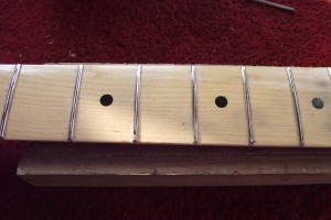 Showing the fret tops all touched by the sanding bar