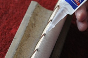 Prior to clipping the frets short, the ends are secured with a drop of super glue